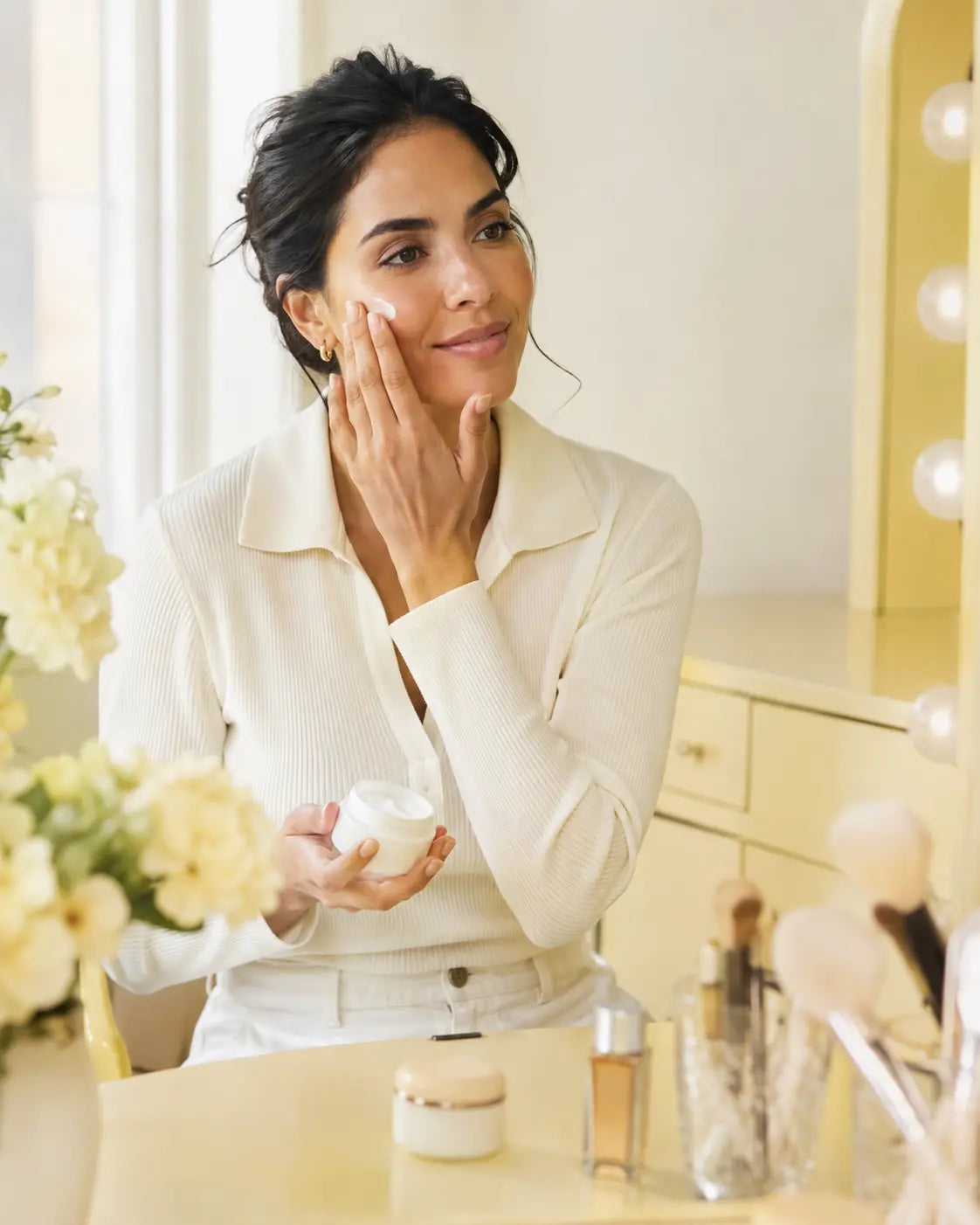 Woman applying moisturizer before makeup